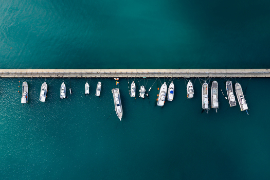 Aerial view of boats moored along a concrete pier in turquoise water at Itoshima Peninsula Itoshima Fukuoka Japan. Aerial view of boats moored along a concrete pier in turquoise water at Itoshima Peninsula Itoshima Fukuoka Japan.
