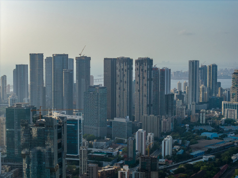 Aerial view of the dense modern skyline of Mumbai featuring numerous high rise skyscrapers construction cranes and urban development along the coast in Mumbai Maharashtra India. Aerial view of the dense modern skyline of Mumbai featuring numerous high rise skyscrapers construction cranes and urban development along the coast in Mumbai Maharashtra India.