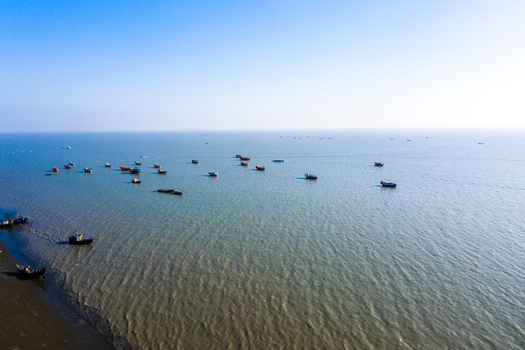 Aerial view of fishing boats scattered across the calm waters of the Bay of Bengal near the coast of Kuakata Barisal Division Bangladesh. Aerial view of fishing boats scattered across the calm waters of the Bay of Bengal near the coast of Kuakata Barisal Division Bangladesh.
