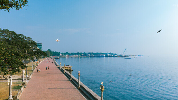 Aerial view of the Rizal Boulevard promenade with its iconic red brick path lush trees and street lamps along the coastline in Dumaguete City Negros Island Region Philippines. Aerial view of the Rizal Boulevard promenade with its iconic red brick path lush trees and street lamps along the coastline in Dumaguete City Negros Island Region Philippines.