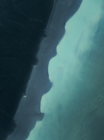 Aerial view of the dramatic coastline featuring the striking contrast between dark volcanic sand and vibrant turquoise glacial meltwater in Iceland. Aerial view of the dramatic coastline featuring the striking contrast between dark volcanic sand and vibrant turquoise glacial meltwater in Iceland.