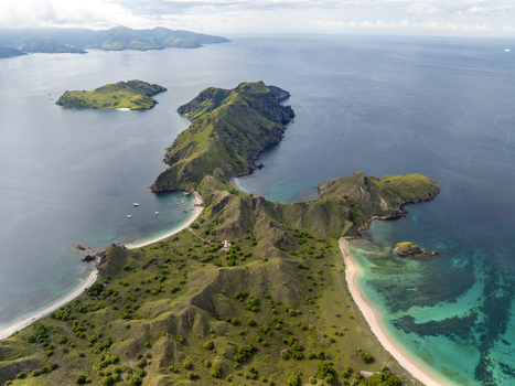 Aerial view of Padar Island with its iconic crescent shaped beaches rugged green hills and turquoise waters in Komodo East Nusa Tenggara Indonesia. Aerial view of Padar Island with its iconic crescent shaped beaches rugged green hills and turquoise waters in Komodo East Nusa Tenggara Indonesia.