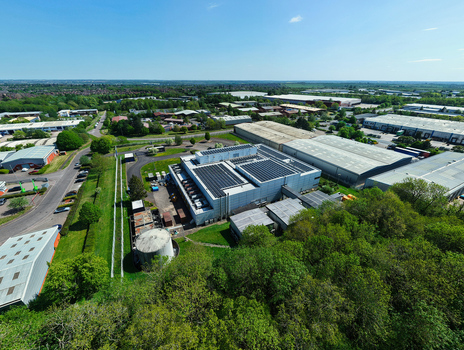 Aerial view of a modern data centre with solar panels on the roof situated in an industrial park surrounded by green trees in Wellingborough England United Kingdom. Aerial view of a modern data centre with solar panels on the roof situated in an industrial park surrounded by green trees in Wellingborough England United Kingdom.