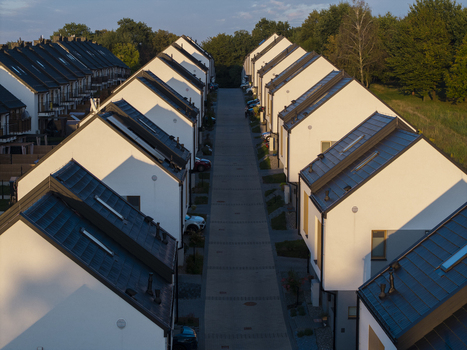 Aerial view of modern terraced houses with dark roofs lining a paved residential street in Wieliczka Lesser Poland Voivode Poland.