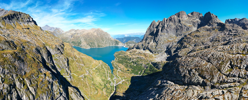 Aerial view of the Barrage d Emosson reservoir surrounded by rugged alpine mountains and winding roads in Finhaut Valais Switzerland.