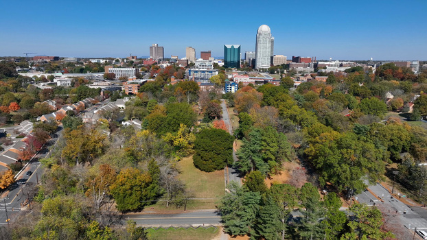 Aerial view of the Winston Salem skyline featuring modern skyscrapers lush autumn foliage and residential streets in Winston Salem North Carolina United States.