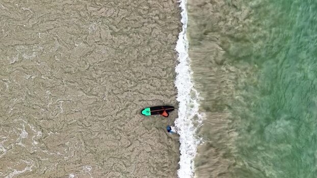 Aerial view of a surfer in the shallow surf zone Indonesia.