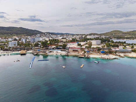 Aerial view of the coastal town with its turquoise waters sandy beaches hotels and surrounding hills in Ksamil Vlore County Albania. Aerial view of the coastal town with its turquoise waters sandy beaches hotels and surrounding hills in Ksamil Vlore County Albania.