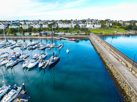 Aerial view of Bangor Harbour and Town with sailboats and yachts moored in the marina a long stone pier and coastal buildings in Bangor Northern Ireland United Kingdom.