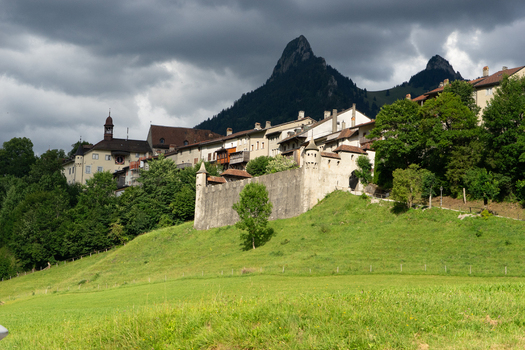 Gruyeres Switzerland 14 May 2026 View of the medieval town and castle walls with the Dent de Broc mountain peak under a dramatic cloudy sky. Gruyeres Switzerland 14 May 2026 View of the medieval town and castle walls with the Dent de Broc mountain peak under a dramatic cloudy sky.