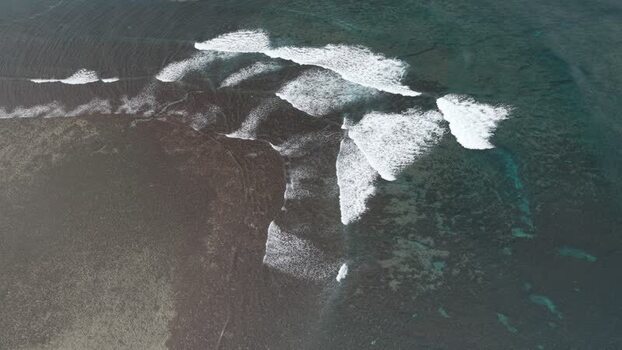 Aerial view of waves breaking over a reef in Siargao Philippines.