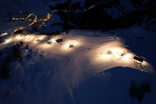 Aerial view of Les Crosets ski resort at night with illuminated slopes ski lifts and snow covered mountain peaks in Val d Illiez Valais Switzerland. Aerial view of Les Crosets ski resort at night with illuminated slopes ski lifts and snow covered mountain peaks in Val d Illiez Valais Switzerland.