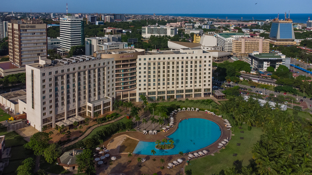 Accra Ghana 26 May 2023 Aerial view of Movenpick Ambassador Hotel Accra featuring its large swimming pool landscaped gardens and the surrounding urban skyline. Accra Ghana 26 May 2023 Aerial view of Movenpick Ambassador Hotel Accra featuring its large swimming pool landscaped gardens and the surrounding urban skyline.
