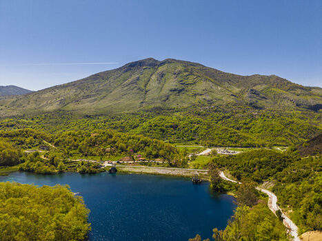 Aerial view of the Blue Eye spring with its vibrant deep blue water surrounded by lush green hills and dense forest in Finiq Vlore County Albania. Aerial view of the Blue Eye spring with its vibrant deep blue water surrounded by lush green hills and dense forest in Finiq Vlore County Albania.
