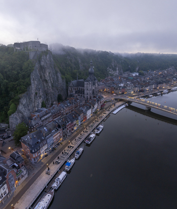 Aerial view of the Collegiate Church of Our Lady of Dinant and the Citadel of Dinant perched on a cliff above the Meuse River in Dinant Wallonia Belgium. Aerial view of the Collegiate Church of Our Lady of Dinant and the Citadel of Dinant perched on a cliff above the Meuse River in Dinant Wallonia Belgium.