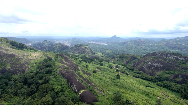 Aerial view of Idanre Hill featuring dramatic rocky outcrops and lush green vegetation under a cloudy sky in Idanre Ondo State Nigeria. Aerial view of Idanre Hill featuring dramatic rocky outcrops and lush green vegetation under a cloudy sky in Idanre Ondo State Nigeria.