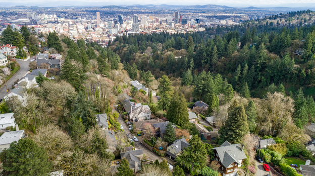 Aerial view of Northwest Imperial Terrace residential neighborhood with lush green trees and the city skyline in the distance Portland Oregon United States. Aerial view of Northwest Imperial Terrace residential neighborhood with lush green trees and the city skyline in the distance Portland Oregon United States.