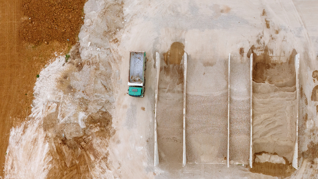 Aerial view of a dump truck parked next to gravel storage bays at an industrial site in Sabac Vojvodina Serbia.