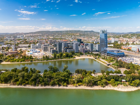 Aerial view of Mol Tower and the Budapest skyline along the Danube near Kopaszi Dam with office buildings roads parks and the Buda Hills in a modern business district. Aerial view of Mol Tower and the Budapest skyline along the Danube near Kopaszi Dam with office buildings roads parks and the Buda Hills in a modern business district.