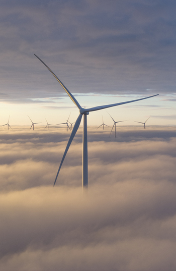 Aerial view of wind turbines rising above a thick layer of clouds during a golden sunrise in Netherlands. Aerial view of wind turbines rising above a thick layer of clouds during a golden sunrise in Netherlands.