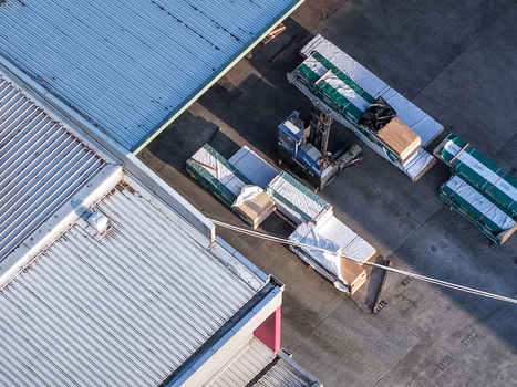 Melbourne Australia 22 September 2026 Aerial view of industrial factory in Kilsyth with a forklift moving wooden pallets and building materials on a concrete yard near metal roofs. Melbourne Australia 22 September 2026 Aerial view of industrial factory in Kilsyth with a forklift moving wooden pallets and building materials on a concrete yard near metal roofs.