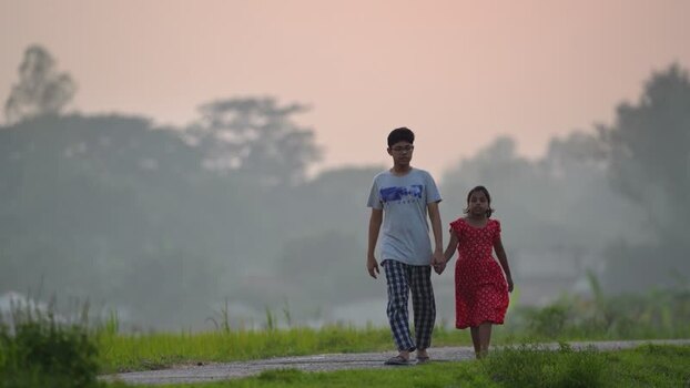 View of children walking along a rural road in Bogura Bangladesh.