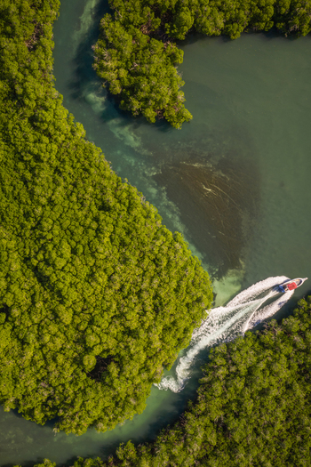 Aerial view of a small boat speeding along the lagoon in Monte Cristi state Dominican Republic.