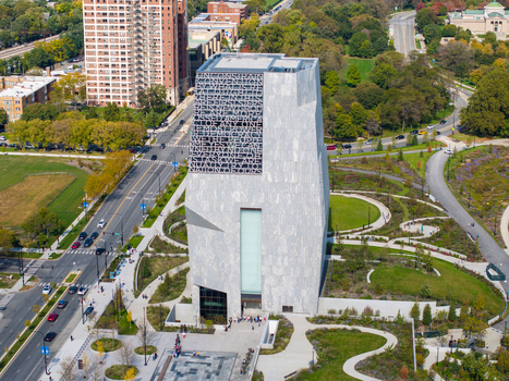 Aerial view of The Obama Presidential Center with its stone facade and text engraved tower surrounded by park grounds and city streets in Chicago Illinois United States. Aerial view of The Obama Presidential Center with its stone facade and text engraved tower surrounded by park grounds and city streets in Chicago Illinois United States.