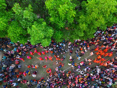 Munshiganj Bangladesh 13 April 2026 Aerial view of a vibrant gathering beneath lush green trees a tapestry of colorful clothing creating a festive ambiance.