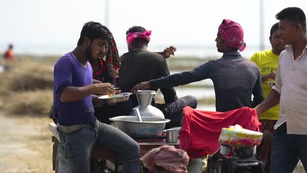 View of men eating lunch on a cart in Jamalpur Bangladesh.