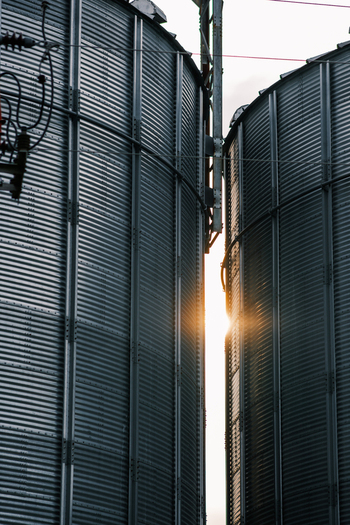 View of sunlight piercing through the gap between two towering metal silos their corrugated surfaces reflecting the light in Sremska Mitrovica Vojvodina Serbia. View of sunlight piercing through the gap between two towering metal silos their corrugated surfaces reflecting the light in Sremska Mitrovica Vojvodina Serbia.