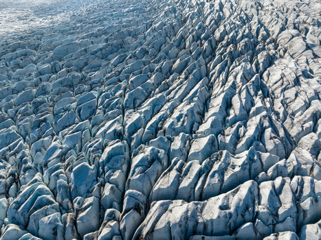 Aerial view of the intricate crevasses and deep fissures of a massive glacier in Iceland. Aerial view of the intricate crevasses and deep fissures of a massive glacier in Iceland.