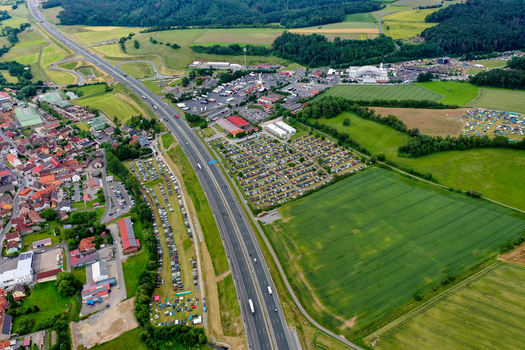 Geiselwind Germany 20 June 2025 Aerial view of the Heroes Festival Geiselwind grounds with crowded parking lots next to the Autobahn A3 and green fields.