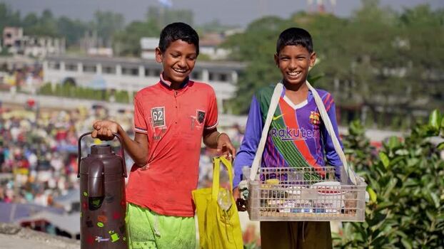 View of two young boys selling tea in a crowded market Bangladesh.