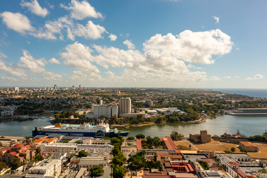 Aerial view of the historic Zona Colonial featuring colonial architecture the Ozama River a ferry at the port and urban landscape in Santo Domingo Distrito Nacional Dominican Republic. Aerial view of the historic Zona Colonial featuring colonial architecture the Ozama River a ferry at the port and urban landscape in Santo Domingo Distrito Nacional Dominican Republic.