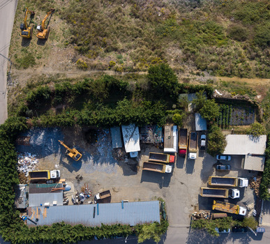 Aerial view of construction machinery including excavators and dump trucks parked at an industrial site surrounded by trees in Istanbul Istanbul Turkiye.