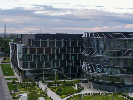 Aerial view of modern glass office buildings with curved architecture landscaped green spaces and walkways in Krakow Lesser Poland Voivode Poland.