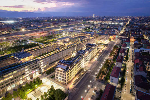 Aerial view of the historic Lingotto building featuring its iconic rooftop test track illuminated at dusk in Turin Piedmont Italy. Aerial view of the historic Lingotto building featuring its iconic rooftop test track illuminated at dusk in Turin Piedmont Italy.