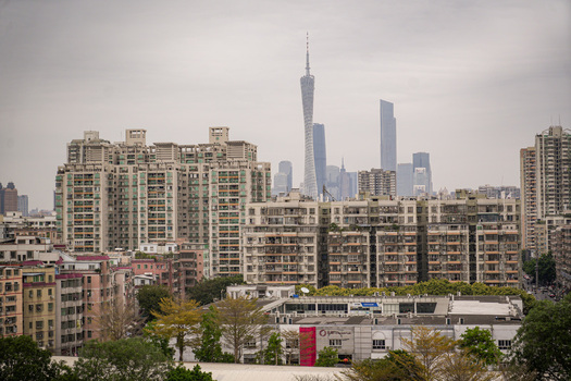 Aerial view of the Canton Tower rising above the dense urban skyline and residential buildings in Guangzhou Guangdong Province China. Aerial view of the Canton Tower rising above the dense urban skyline and residential buildings in Guangzhou Guangdong Province China.