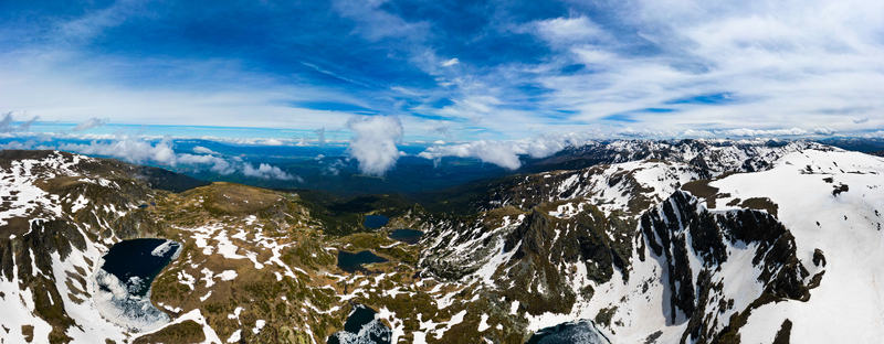 Aerial view of Seven Rila Lakes featuring snow covered mountain peaks glacial lakes and alpine terrain in Kyustendil Province Bulgaria. Aerial view of Seven Rila Lakes featuring snow covered mountain peaks glacial lakes and alpine terrain in Kyustendil Province Bulgaria.