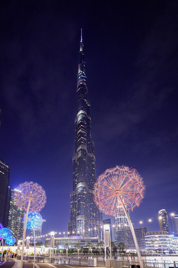 Dubai United Arab Emirates 19 April 2023 View of the Burj Khalifa illuminated at night with dandelion shaped light sculptures in the foreground. Dubai United Arab Emirates 19 April 2023 View of the Burj Khalifa illuminated at night with dandelion shaped light sculptures in the foreground.