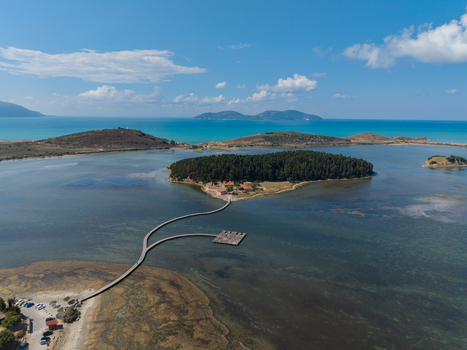 Aerial view of Zvernec Islands featuring the historic Zvernec Monastery surrounded by the calm waters of Narta Lagoon and connected by a long wooden footbridge in Vlore Vlore County Albania. Aerial view of Zvernec Islands featuring the historic Zvernec Monastery surrounded by the calm waters of Narta Lagoon and connected by a long wooden footbridge in Vlore Vlore County Albania.