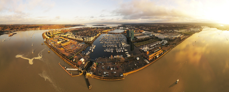Aerial view of the marina and waterfront development with numerous boats docked in the harbour during golden hour in Chatham England United Kingdom.
