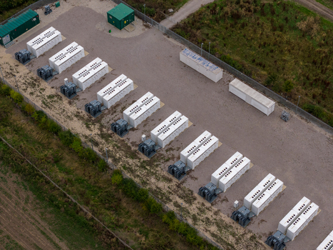 Aerial view of Chapel Farm Energy Park featuring rows of white battery storage containers and electrical transformers on a gravel site in Luton England United Kingdom. Aerial view of Chapel Farm Energy Park featuring rows of white battery storage containers and electrical transformers on a gravel site in Luton England United Kingdom.