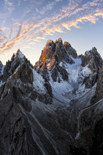 Aerial view of jagged Cadini di Misurina peaks kissed by the sun s golden light where snow drapes the rugged terrain Dolomites Italy. Aerial view of jagged Cadini di Misurina peaks kissed by the sun s golden light where snow drapes the rugged terrain Dolomites Italy.