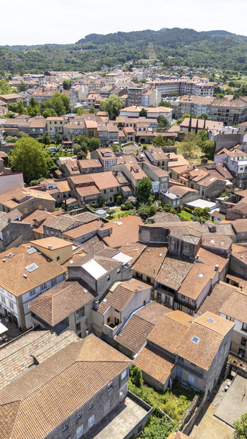 Aerial view of the historic town with its dense cluster of terracotta tiled rooftops stone buildings and lush green surroundings in Allariz Province of Ourense Spain. Aerial view of the historic town with its dense cluster of terracotta tiled rooftops stone buildings and lush green surroundings in Allariz Province of Ourense Spain.