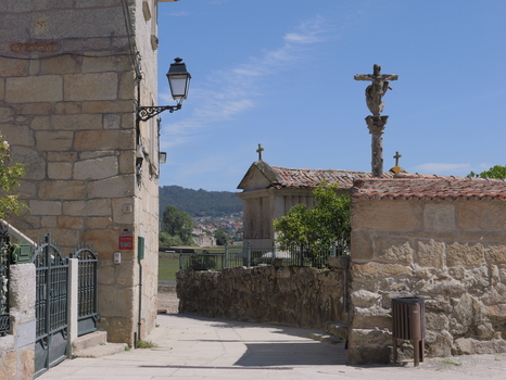 View of the historic stone horreos and traditional stone cross in the coastal village of Combarro Pontevedra Spain.