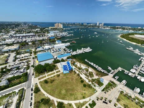 Aerial view of Peanut Island and the surrounding marinas with numerous boats docked in the turquoise water under a clear blue sky in Palm Beach County Florida United States.