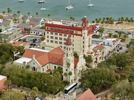 Aerial view of the historic Cathedral Basilica of St. Augustine and Casa Monica Resort with red tiled roofs and palm trees near the waterfront in St. Augustine Florida United States.