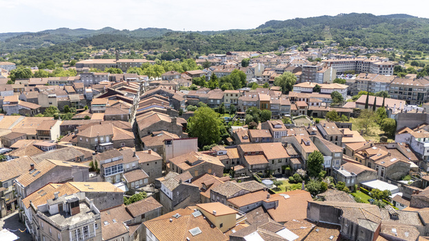 Aerial view of the historic town of Allariz featuring traditional terracotta rooftops and stone architecture surrounded by lush green hills in Allariz Province of Ourense Spain. Aerial view of the historic town of Allariz featuring traditional terracotta rooftops and stone architecture surrounded by lush green hills in Allariz Province of Ourense Spain.